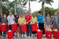 Lãnh đạo cùng các tình nguyện viên Chữ thập đỏ trao hàng thiết yếu tới nhân dân vùng thiệt hại do thiên tai ở Thanh Hóa.