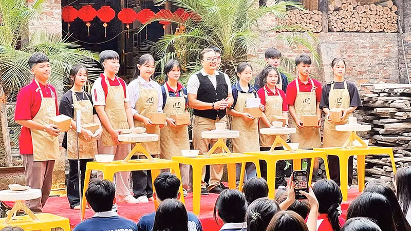 Khách du lịch trải nghiệm tại lò gốm cổ tại làng gốm Bát Tràng. 