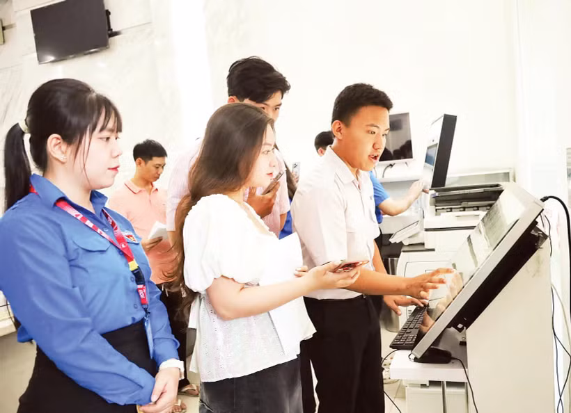 Sinh viên Học viện Cán bộ Thành phố Hồ Chí Minh hướng dẫn người dân thực hiện thủ tục hành chính tại Ủy ban nhân dân phường Sài Gòn.