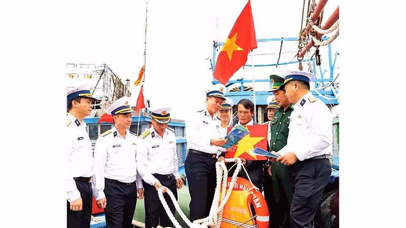 Chuẩn Đô đốc Nguyễn Đăng Tiến, Bí thư Đảng ủy, Chính ủy Vùng 3 Hải quân (người thứ tư từ trái qua) tuyên truyền biển đảo cho ngư dân.