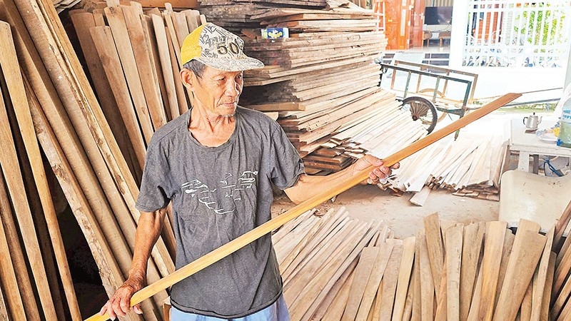 Ông Nguyễn Văn Nên kiểm tra độ trơn láng của các cây dầm. 