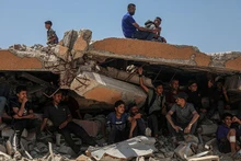Người dân Palestine ngồi trên đống đổ nát ở khu vực Sudaniya, phía bắc thành phố Gaza. (Ảnh: Tân Hoa Xã/TTXVN)