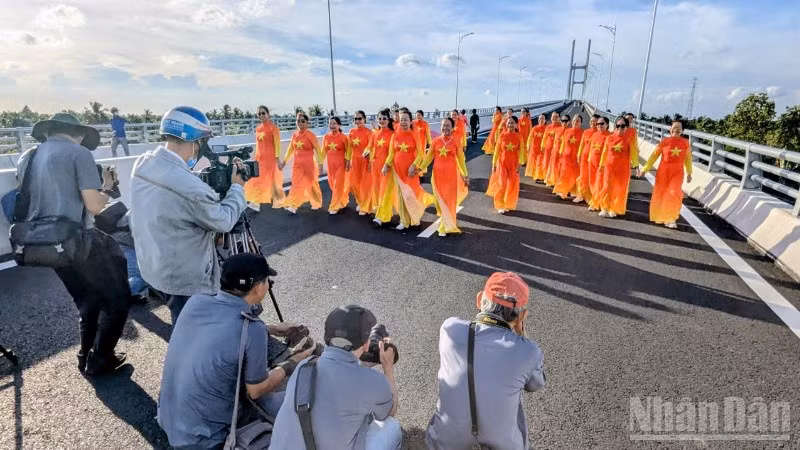 Người dân chụp ảnh lưu niệm trên cầu Rạch Miễu 2 trước ngày khánh thành, đưa vào sử dụng. (Ảnh: TRUNG HIẾU)