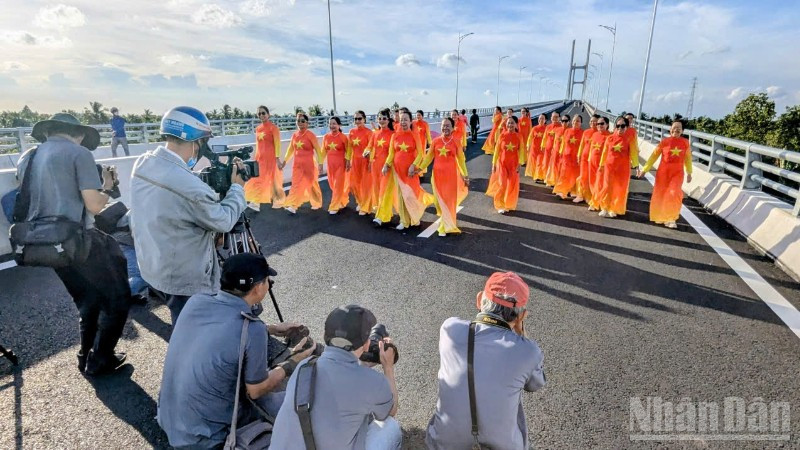 Người dân chụp ảnh lưu niệm trên cầu Rạch Miễu 2 trước ngày khánh thành, đưa vào sử dụng. (Ảnh: TRUNG HIẾU)