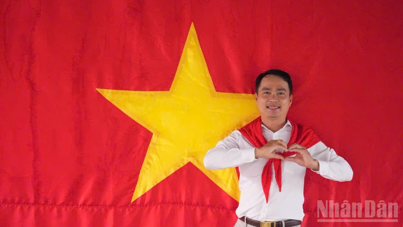 Tiến sĩ Võ Văn Sơn, giảng viên trẻ của Trường đại học Tiền Giang chụp ảnh cùng cờ Tổ quốc.