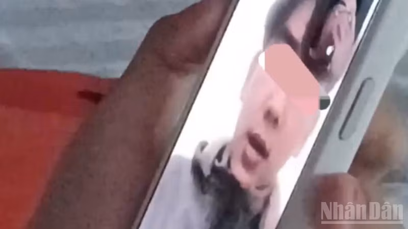 Ảnh cắt từ clip em T.D.H gọi điện thoại thông báo cho gia đình.