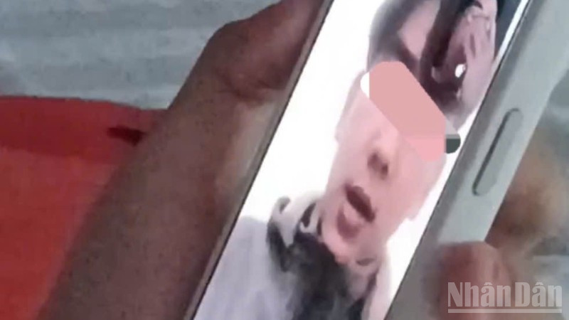 Ảnh cắt từ clip em T.D.H gọi điện thoại thông báo cho gia đình.