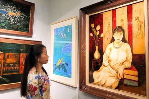 Công chúng thưởng thức tác phẩm tại không gian triển lãm “Sắc màu hữu nghị". (Ảnh: TTXVN)