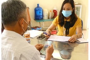 Chi trả hỗ trợ cho người bị ảnh hưởng bởi Covid-19 theo Nghị quyết 68 ở phường Thạch Bàn, quận Long Biên, Hà Nội (Ảnh: Hoàng Hiếu)