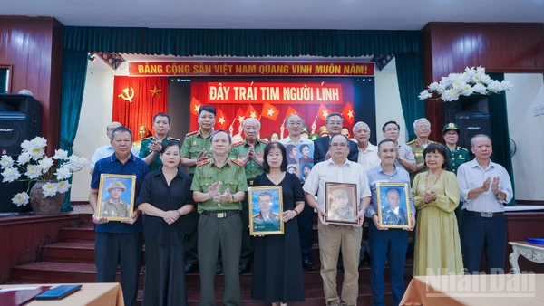 Đại diện các gia đình đón nhận di ảnh anh hùng liệt sĩ tại sự kiện. 