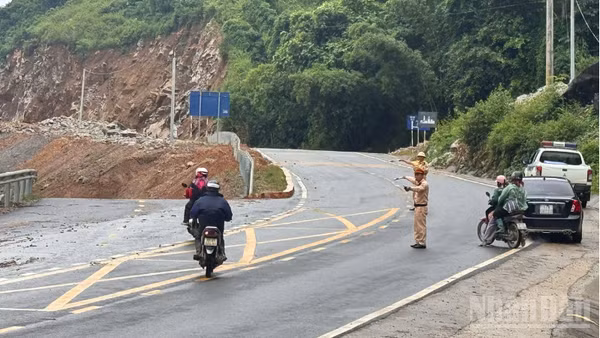 Cảnh sát giao thông phân luồng tại khu vực sạt lở trên Quốc lộ 6.