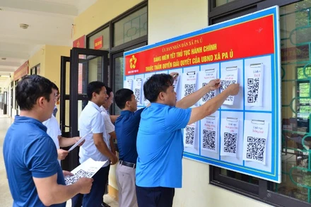 Cán bộ xã Pa Ủ triển khai niêm yết mã QR về thủ tục hành chính tại UBND xã, trụ sở được tận dụng từ trường THCS để làm việc.