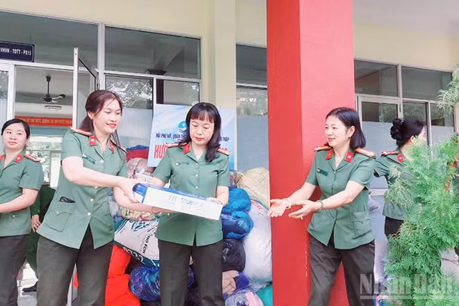 Nữ cán bộ, chiến sĩ chuyển nhu yếu phẩm lên xe hỗ trợ đồng bào miền trung.