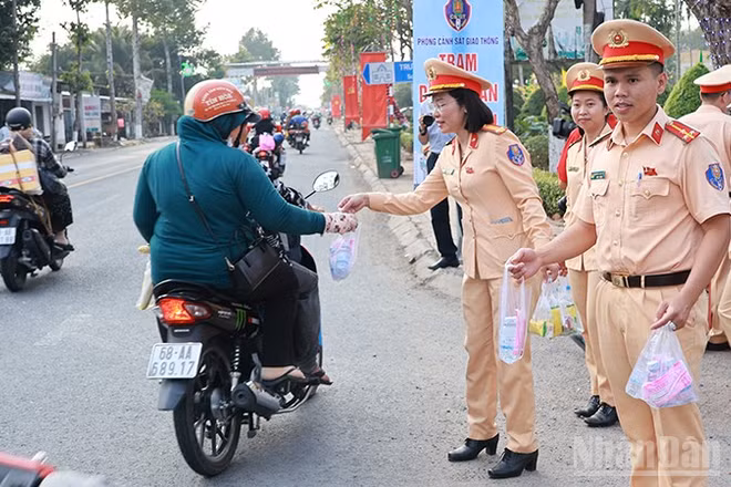 Các lực lượng phát nước suối và khăn lạnh tặng người dân về quê đón Tết.