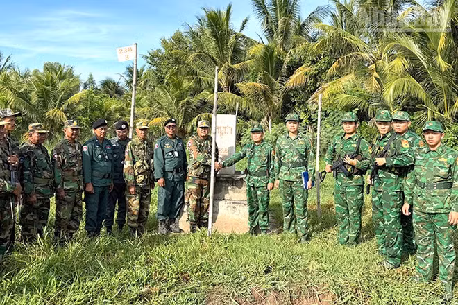 Cán bộ, chiến sĩ 2 bên chụp hình lưu niệm tại cột mốc trong đợt tuần tra song phương.