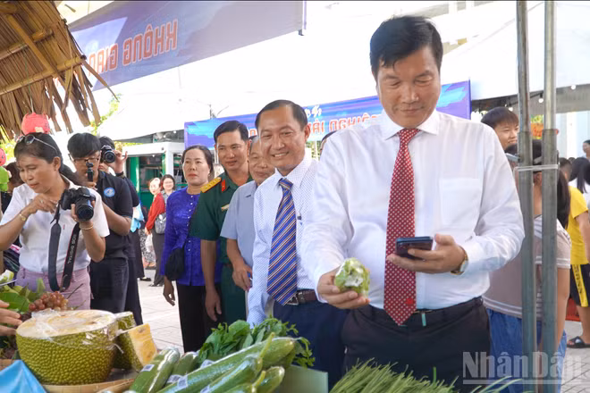 Đồng chí Võ Phan Thành Minh, Bí thư Đảng ủy phường Mỹ Ngãi cùng đại biểu, bà con nhân dân tham quan, trải nghiệm mặt hàng nông sản dán mã QR truy xuất nguồn gốc.