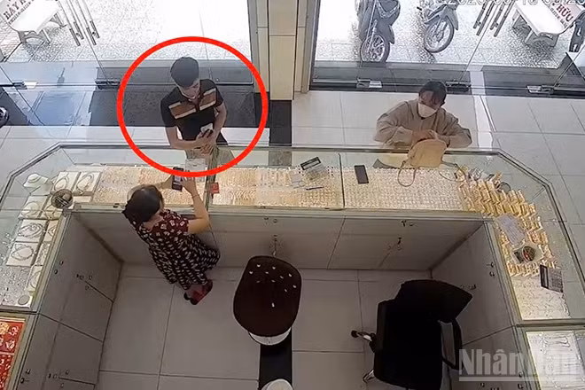 Đối tượng Sang đang thực hiện giao dịch chuyển tiền qua App giả tại cửa hàng kinh doanh vàng (khoanh đỏ).