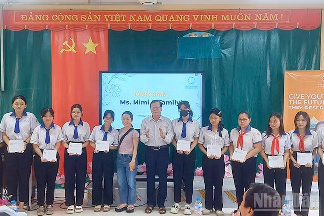 Đại diện nhà tài trợ Vòng tay Thái Bình trao học bổng. (Ảnh: VĂN THẨM)