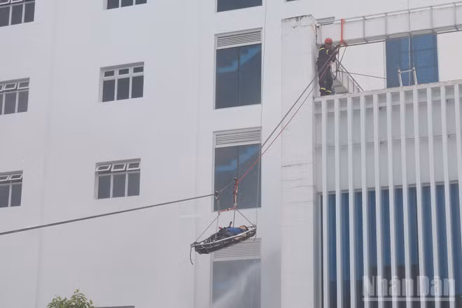 Lực lượng cứu nạn cứu hộ tiếp nhận và đưa người bị nạn xuống đất an toàn trong tình huống giả định xảy ra cháy tại tòa nhà điều hành.