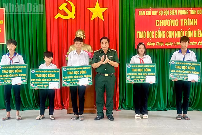 Đại tá Nguyễn Thanh Hòa, Chỉ huy trưởng Ban Chỉ huy Bộ đội Biên phòng tỉnh Đồng Tháp trao học bổng tặng học sinh. (Ảnh: HÒA BÌNH)