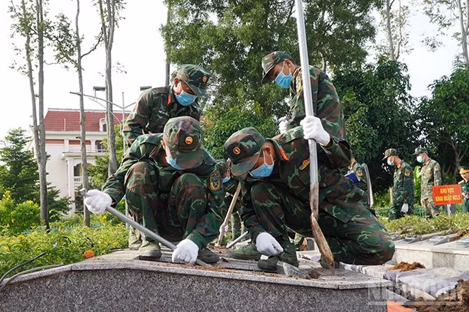 Lực lượng chức năng tiến hành khai quật để lấy mẫu hài cốt liệt sĩ. (Ảnh: HỮU NGHĨA)
