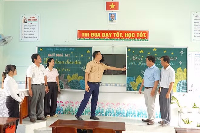 Cán bộ, giáo viên Trường tiểu học Tân Quới và cán bộ Phòng Văn hóa-Thông tin xã Tân Long kiểm tra cơ sở vật chất tại một phòng học của trường. (Ảnh: HỮU NGHĨA)