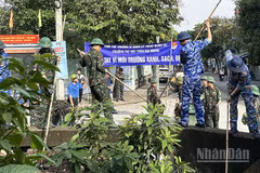 Thanh niên lực lượng vũ trang tham gia dọn vệ sinh, khơi thông dòng chảy rạch Nhà Nuôi. (Ảnh: HOÀNG LIÊM)