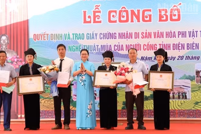 Đồng chí Nguyễn Thị Thanh Chuyên, Phó Giám đốc Sở Văn hóa, Thể thao và Du lịch Điện Biên trao Bằng Công nhận Di sản văn hóa phi vật thể quốc gia cho Nghệ thuật múa của người Cống cho nhân dân dân tộc Cống xã Nậm Kè. (Ảnh: LÊ LAN)