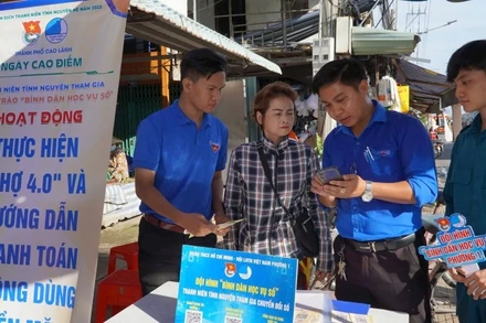 Đoàn viên hướng dẫn tiểu thương thanh toán không dùng tiền mặt tại chợ Mỹ Ngãi, Phường 1, thành phố Cao Lãnh.