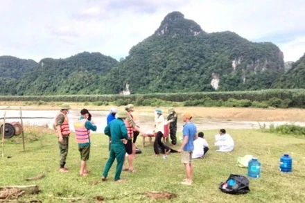 Lực lượng chức năng và gia đình tìm thấy thi thể 1 phụ nữ bị lũ cuốn ở xã Tân Hóa.