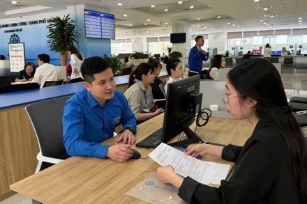 Thanh niên quận Tây Hồ hỗ trợ người dân sử dụng công nghệ số. (Ảnh: ĐĂNG ANH)