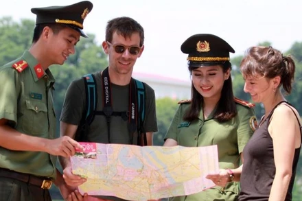 Chiến sĩ Công an thành phố Hà Nội hỗ trợ khách du lịch nước ngoài tham quan Thủ đô. (Ảnh: Lam Thanh)