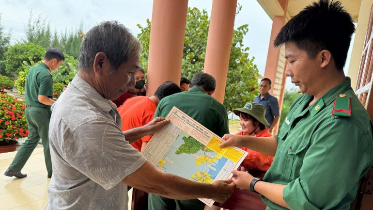 Cán bộ, chiến sĩ Biên phòng phát tờ rơi in chi tiết tọa độ và thông tin các công trình dầu khí giúp ngư dân dễ dàng nhận biết và tránh vi phạm. img-0681-1996.jpg