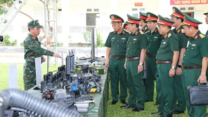 Đoàn công tác tham quan khu vực trưng bày trang thiết bị kỹ thuật.