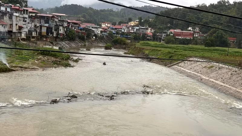 Sau mưa lũ to, hiện một phần đường công vụ cũ vẫn nổi lên, cắt ngang dòng sông Năng. (Ảnh: TUẤN SƠN)