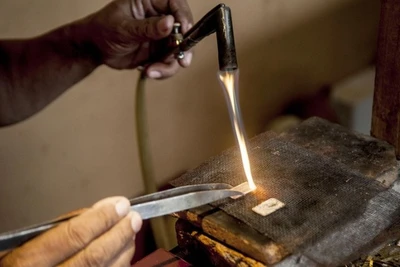 Công nhân đang nung chảy thỏi bạc để làm trang sức bạc tại Cơ sở trang sức bạc HS Silver ở Kotagede, Yogyakarta, Indonesia. (Ảnh: Xinhua)