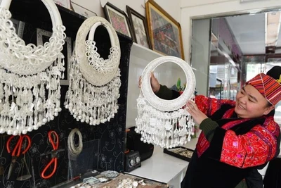 Thợ thủ công giới thiệu các sản phẩm trang sức bạc tại một cửa hàng bạc ở tỉnh Quý Châu, tây nam Trung Quốc. (Ảnh: Xinhua)