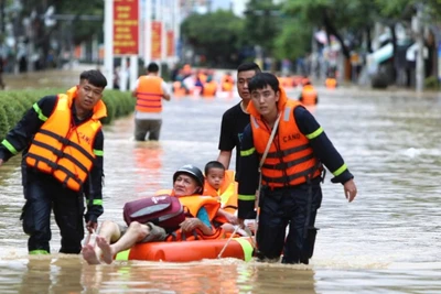 Lực lượng chức năng cứu hộ người dân khỏi khu vực ngập úng tại phường Tây Nha Trang.