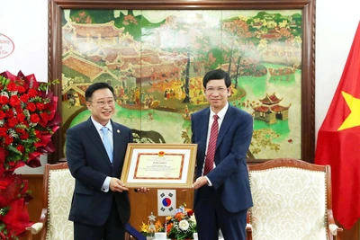 Thứ trưởng Hồ An Phong trao Bằng khen cho ông Lý Xương Căn, Đại sứ Du lịch Việt Nam tại Hàn Quốc. (Ảnh: TRẦN HUẤN)