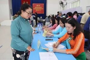 Cán bộ tại Điểm bỏ phiếu số 30 , phường Nam Nha Trang hỗ trợ người dân ghi phiếu.