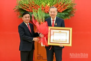 Thường trực Ban Bí thư Trần Cẩm Tú trao huy hiệu 45 năm tuổi đảng, tặng hoa chúc mừng đồng chí Tô Lâm, Tổng Bí thư Ban Chấp hành Trung ương Đảng Cộng sản Việt Nam. (Ảnh: DUY LINH)