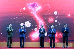 Thường trực Ban Bí thư Trần Cẩm Tú và các đại biểu thực hiện nghi thức ra mắt App TGDV trên điện thoại di động. (Ảnh: DUY LINH) 