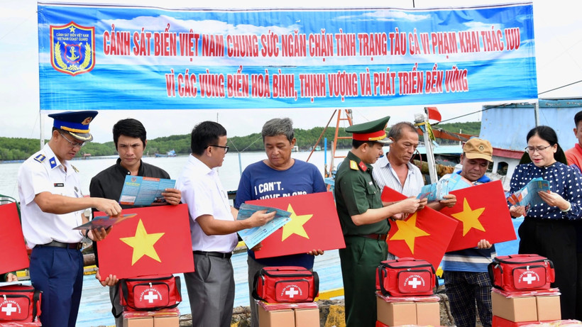 Cảnh sát biển trao cờ Tổ quốc và phát tờ rơi tuyên truyền cho ngư dân tại xã Thạnh An.