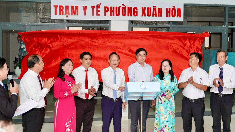 Đại biểu bấm nút đưa Trạm y tế Xuân Hòa vào hoạt động. 