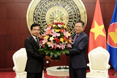 Đại sứ Lào Somphone Sichaleune tặng hoa chúc mừng Đại sứ Phạm Thanh Bình. (Ảnh: Đại sứ quán Việt Nam cung cấp)