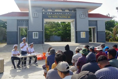 Cán bộ Trung tâm Dịch vụ hậu cần kỹ thuật Trường Sa tuyên truyền, phổ biến cho ngư dân về Chỉ thị 45 và về hoạt động của các âu tàu, làng chài trên quần đảo Trường Sa. (Ảnh: Đức Thuận)