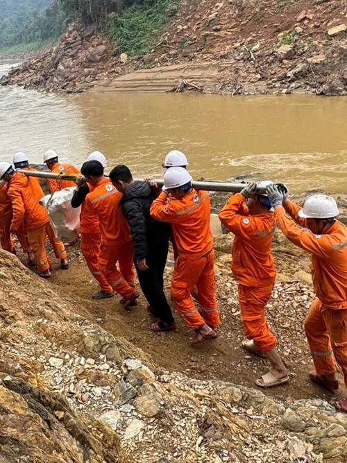 Công nhân vận chuyển máy móc, thiết bị vượt ghềnh đá để xuống thuyền, sau đó vượt qua quãng sông dài với nhiều đoạn thác nguy hiểm để đến được bản.