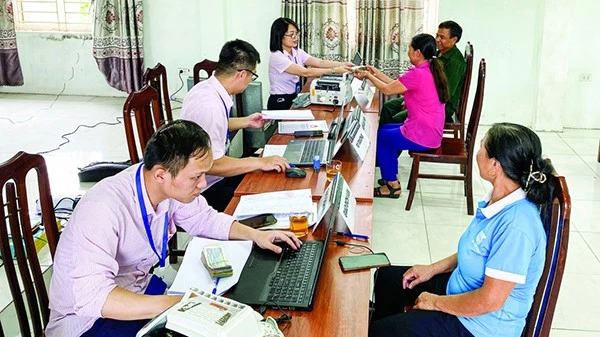 Cán bộ Ngân hàng Chính sách xã hội chi nhánh Hà Nội giải ngân vốn vay cho người dân tại Điểm giao dịch. (Ảnh VBPS)