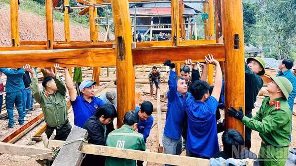 Lực lượng công an và các tổ chức đoàn thể hỗ trợ người dân xã biên giới Nhôn Mai dựng nhà mới sau thiên tai (Ảnh: PHAN TUYẾT)