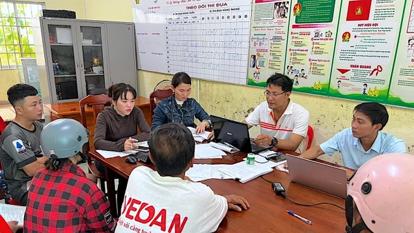 Cán bộ công vụ xã Khánh Hưng, tỉnh Cà Mau tra đối chiếu dữ liệu để phát quà cho người dân địa phương. 